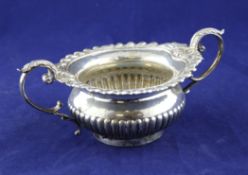 A late Victorian silver demi fluted sugar bowl, with gadrooned rim and acanthus leaf cap handles,