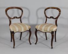 A set of six early Victorian carved rosewood balloon back dining chairs, on cabriole legs