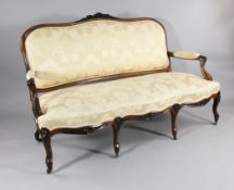 An early Victorian carved rosewood salon settee, with floral upholstery on cabriole legs, 5ft 2ins