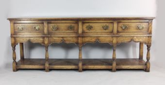 An 18th century style oak dresser, with four short drawers above a pot cupboard on turned legs and