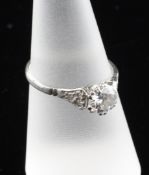 A platinum and solitaire diamond ring, with diamond set shoulders, the central stone approximately