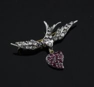 A gold, silver, ruby and diamond set swallow brooch, with heart shaped drop, 1.5in.
