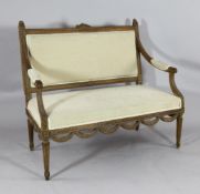 A 19th century French carved beech canape, with beige upholstered back, arms and seat, on fluted