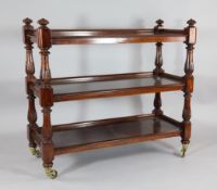 An early Victorian carved mahogany three tier buffet, with fitted pierced brass castors, 3ft 6in.