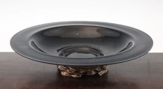 A Chinese Beijing black glass dish, 19th century, of shallow form with a barbed rim, 14.5in.; wood