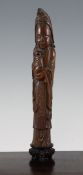 A Chinese bamboo standing figure of Guanyin, holding a vase in both hands, on a wood stand, 13.6in.