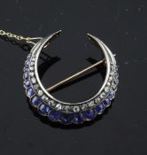 A Victorian gold and silver sapphire and diamond set crescent brooch, with safety chain, 1.25in.