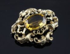 A Victorian open scroll gold brooch, set with a large oval citrine, of quatrefoil shape, 2.25in.
