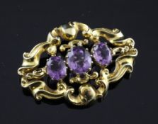 A Victorian style open scroll 9ct gold brooch set with three oval cut amethysts, of quatrefoil