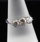 An 18ct white gold three stone diamond ring, in pierced scroll setting, total weight approximately
