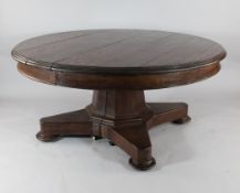 A William IV oak circular dining table, with hexagonal column on a platform and disc feet, ex