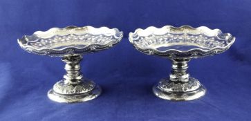 A pair of Victorian silver tazze, with wavy rims and embossed with foliate decoration, on turned