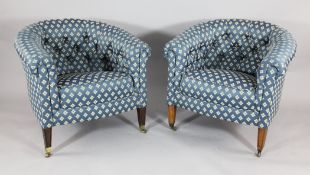 A pair of Edwardian stained pine button back tub chairs, with blue floral upholstery, on tapered
