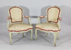 A pair of Louis XV style carved and painted beech fauteuils, 19th century, with striped upholstery