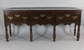 An early 18th century oak dresser base, with three short drawers on turned and block legs, 2ft