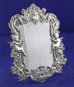 A late 19th century Continental silver photograph frame, embossed with cherubs and foliate