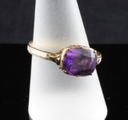 A George III enamelled gold memorial ring, inset with a foiled amethyst with white enamelled band,