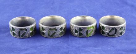 A cased set of four(ex six) late Victorian/Edwardian silver and hardstone napkin rings, each