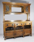 An Arts & Crafts oak dresser in the manner of Liberty & Co, with two copper inset doors and shelf