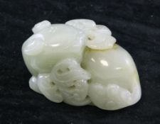 A Chinese celadon jade carving of a cat biting lingzhi fungus, the stone with russet inclusions,