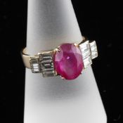 A gold, ruby and diamond dress ring, the central oval cut ruby approximately 3.60ct, with baguette