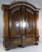A Dutch oak and walnut armoire, in 17th century style, with arched top above a pair of panelled