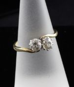 A 1920`s 18ct gold and platinum two stone diamond cross-over ring, total diamond weight