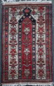 A Persian prayer rug, with three rows of foliate medallions, on a red and ivory ground and two row