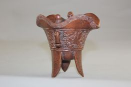A Chinese bamboo archaistic vessel, jue, carved in low relief with a band of scrolls and taotie