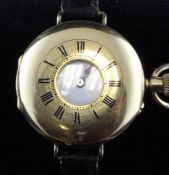 A 1920`s 18ct gold half hunter keyless fob watch, now converted to a wrist watch, with Roman dial