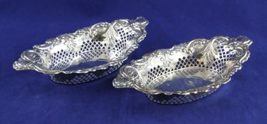 A pair of late Victorian pierced repousse silver bonbon dishes, with floral scroll decoration,
