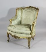 A Louis XV style carved giltwood and gesso armchair, 19th century, with beige upholstery, on