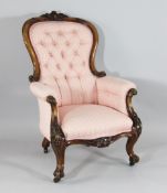 A Victorian carved walnut show frame salon chair, with buttonback pink upholstery, on cabriole