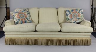 A late 20th century three seater sofa, upholstered in cream fabric, 7ft