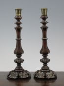 A pair of George IV carved rosewood candlesticks, with fitted brass sconces on acanthus leaf lead