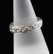 A platinum and diamond full eternity ring, the foliate scroll carved shank set with nineteen