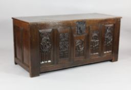 A late 17th century and later oak coffer, the panelled front carved with foliate gothic roundels, on