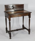 An Edwardian oak writing table, the leather inset top with integral stationery box and silvered