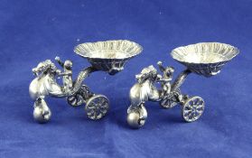 A pair of late 19th/early 20th century Hanau? novelty silver table salts, modelled as putti on sea