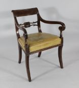 A Regency carved mahogany carver chair, with leather seat on sabre legs
