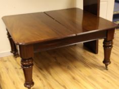 A Victorian mahogany dining table, with two leaves on turned legs and brass casters, (some later