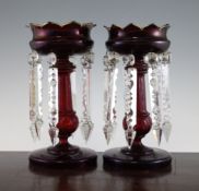 A pair of ruby glass table lustres, late 19th century, with petal cut rims above knopped stems, with