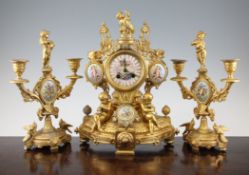 A late 19th century French gilt metal clock garniture, inset with porcelain plaques decorated with