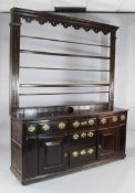 A George III oak dresser, with two tier plate rack above three short drawers, an arrangement of