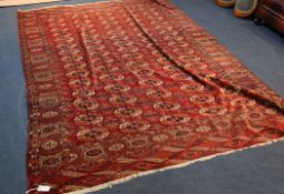 A Bokhara red ground carpet, woven with rows of elephant foot design, 10ft 6in. x 7ft