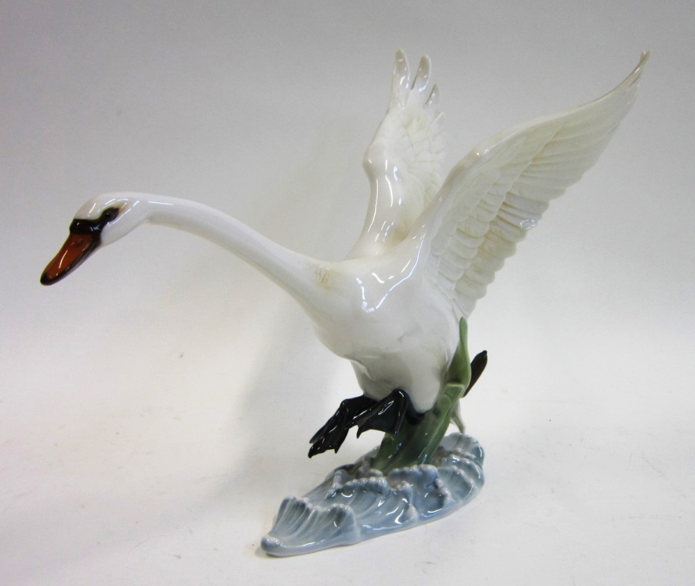 A Hutschenheuther porcelain model of a Swan landing in water. 22 cms high