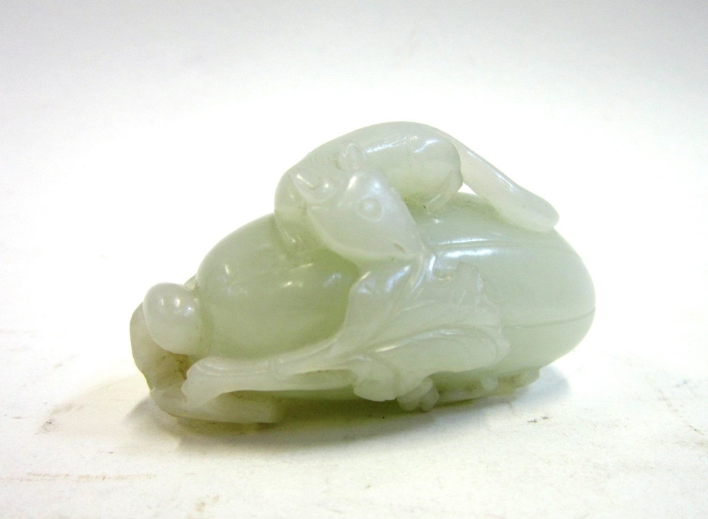 A Chinese pale celadon jade Carving of a Squirrel atop a large melon with foliage, 6 cms long