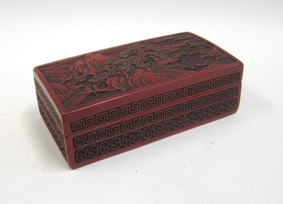 A Chinese Cinnabar lacquer Box. The cover carved with an extensive mountainous landscape, the
