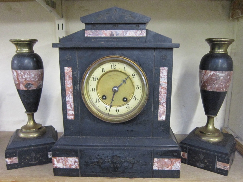 A Victorian Garniture comprising a Mantel Clock in black slate case and a pair of brass mounted