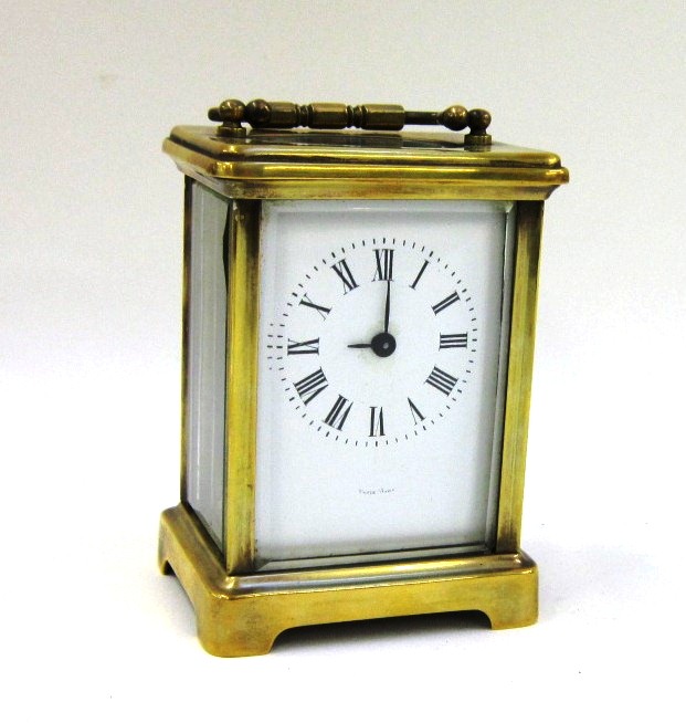 A French brass Carriage Clock, the white enamel dial with Roman numerals with key, 11 cms high (back